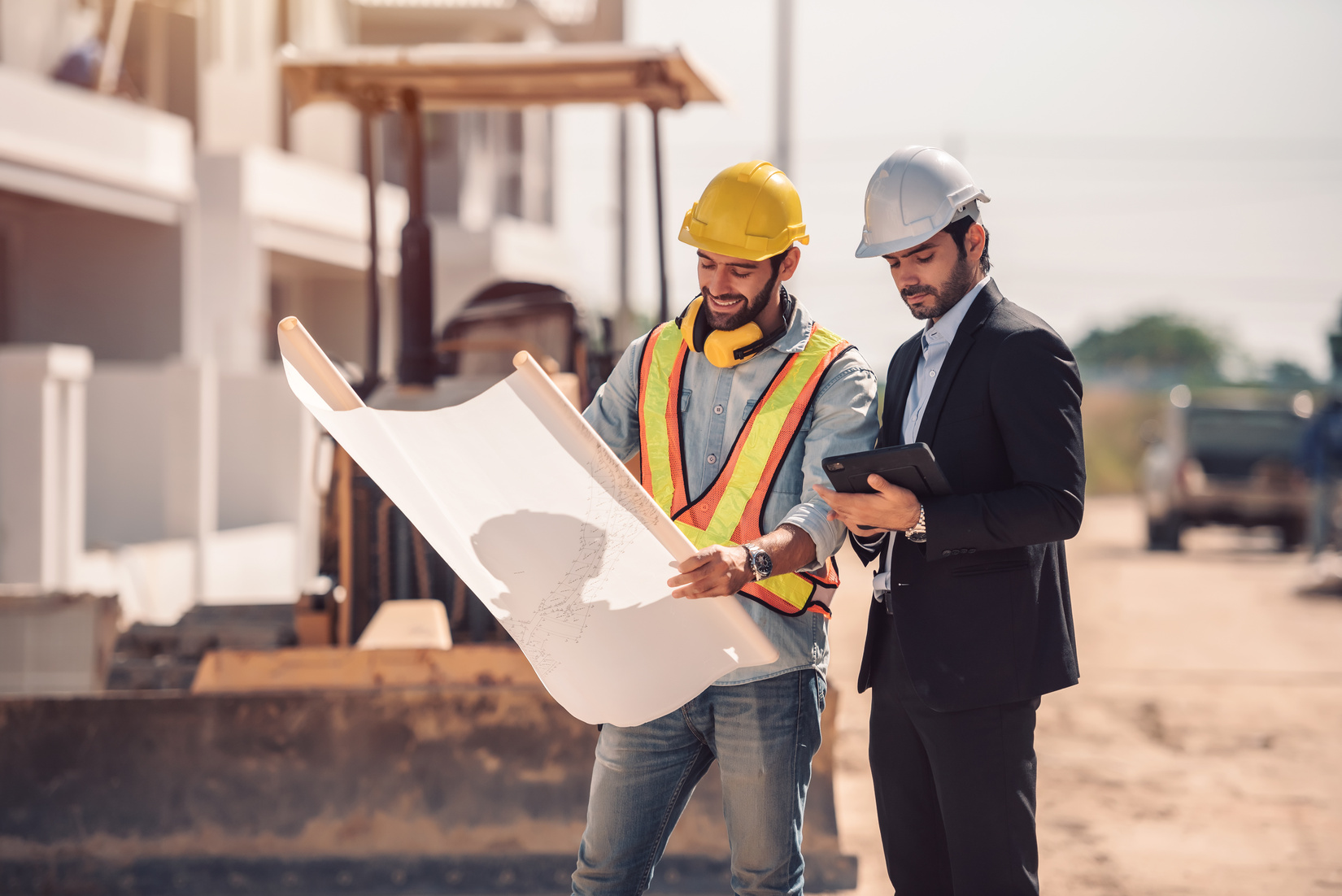 Civil engineer and construction worker in construction site.